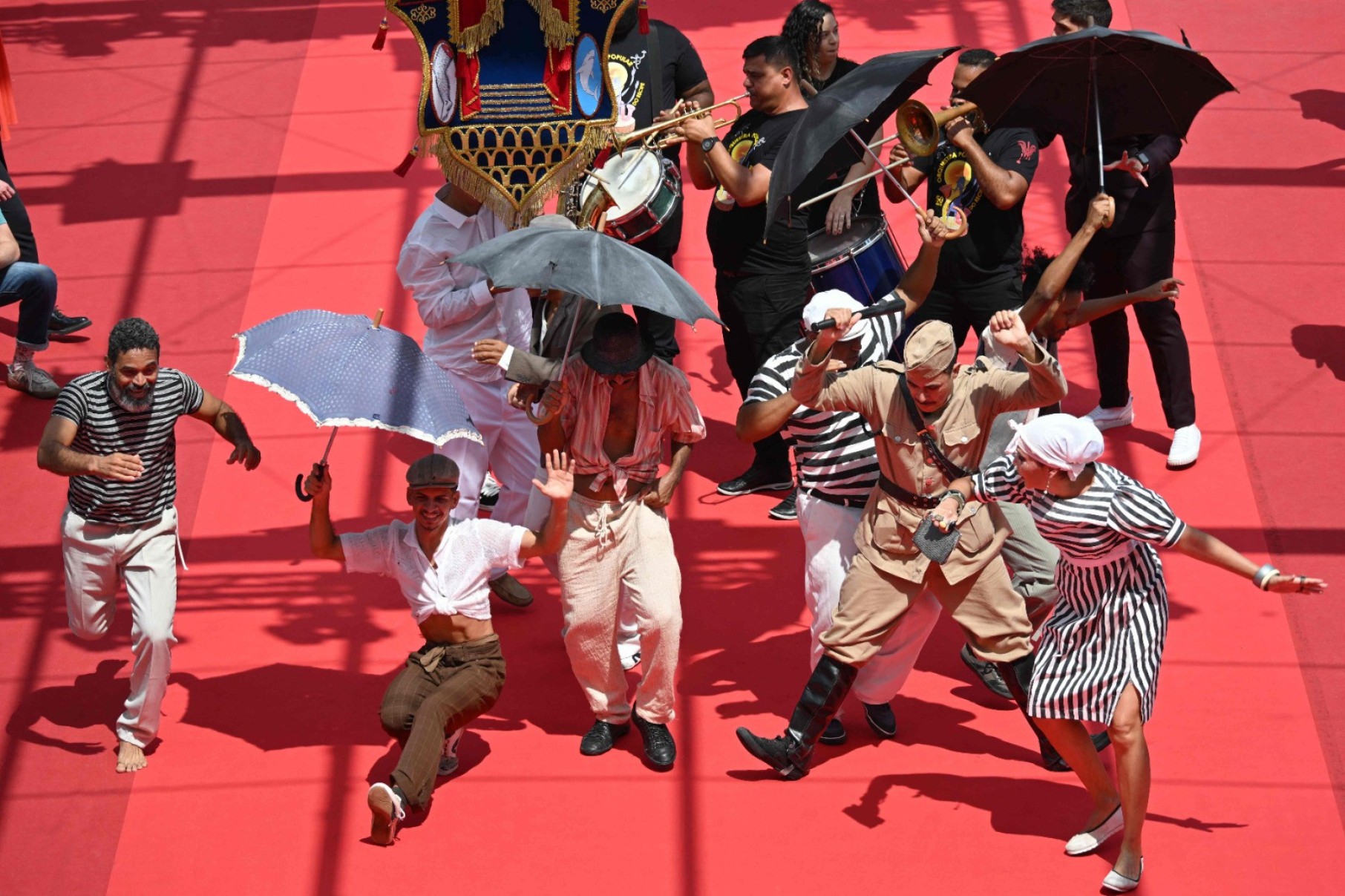 A entrada do elenco de "O agente secreto" em Cannes foi acompanhada por músicos da Orquestra Popular do Recife e do grupo de frevo Guerreiros do Passo.-Antonin Thuillier/AFP