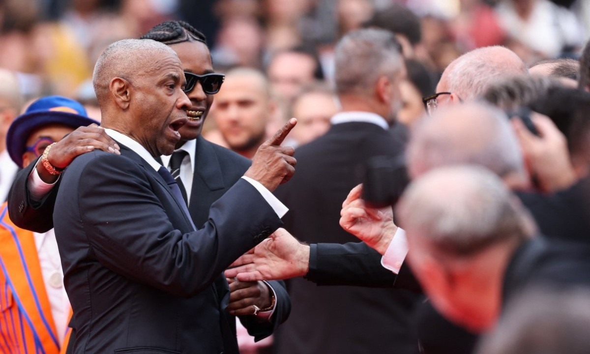 Ator americano Denzel Washington discute com fotógrafo ao lado do cantor e ator americano ASAP Rocky quando chegavam para a exibição do filme "Highest 2 Lowest" no Festival de Cannes -  (crédito: Sameer AL-DOUMY / AFP)