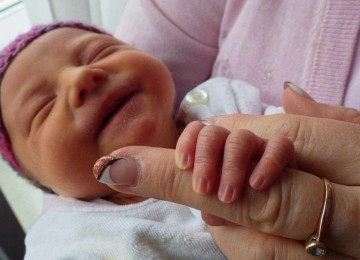 Bebê reborn segura dedo de mulher; imagem meramente ilustrativa -  (crédito: Pixabay)