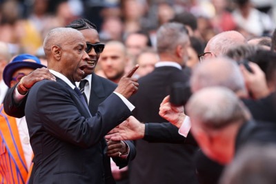 Ator americano Denzel Washington discute com fotógrafo ao lado do cantor e ator americano ASAP Rocky quando chegavam para a exibição do filme 'Highest 2 Lowest' no Festival de Cannes -  (crédito: Sameer AL-DOUMY / AFP)