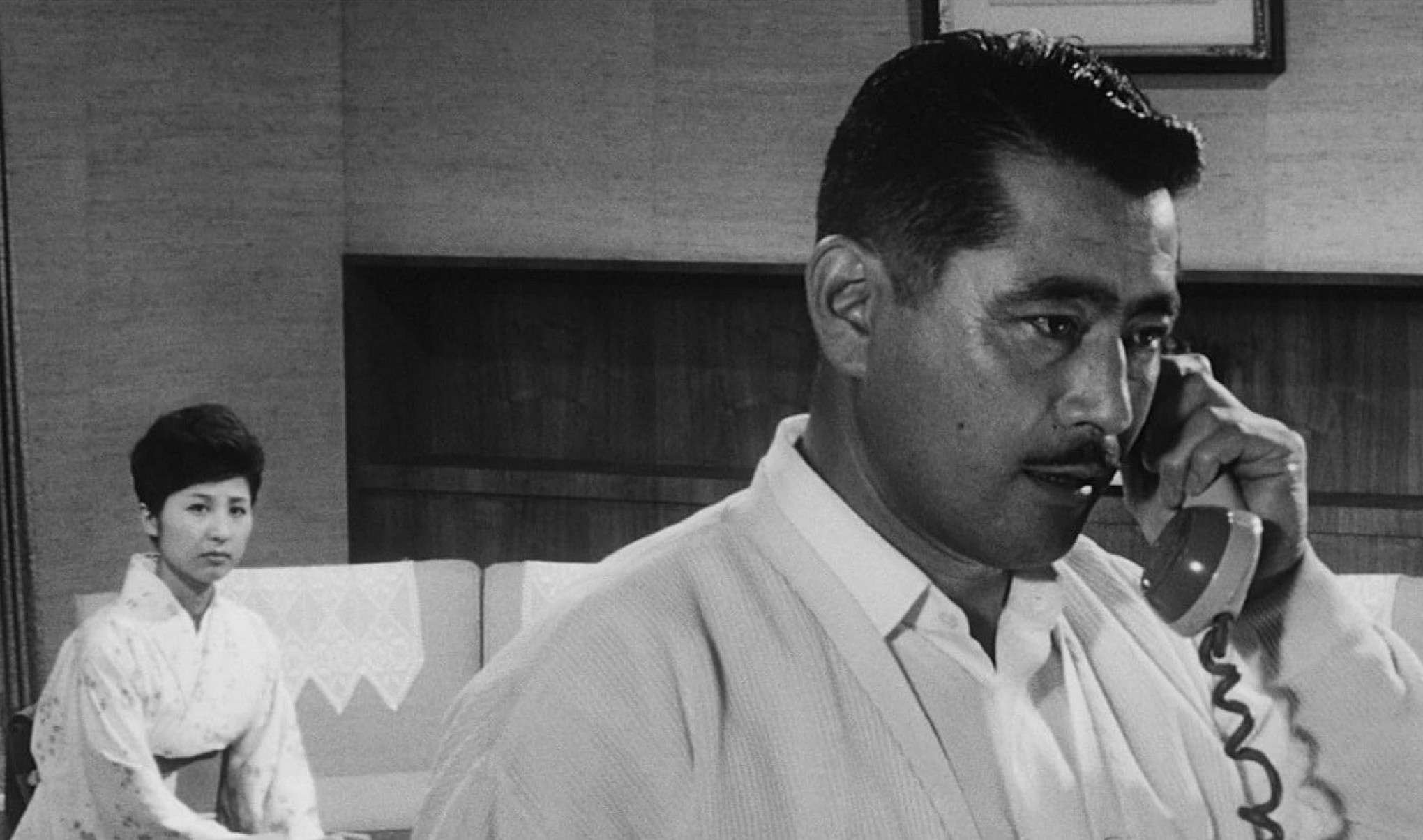 Atriz Kyoko Kagawa está sentada e ator Toshiro Mifune fala ao telefone em cena do filme 'Céu e inferno', policial de Akira Kurosawa lançado em 1963 