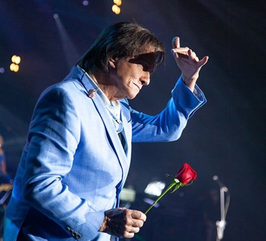 Uma das marcas registradas de Roberto Carlos é distribuir rosas para a plateia de seus shows. O ritual surgiu em 1978, quando o cantor identificou uma conhecida em meio ao público, retirou um cravo de sua lapela e atirou para ela. A maquiadora Neide de Paula sugeriu que o artista asse a ofertar flores nas apresentações, mas que optasse por rosas por serem mais firmes que cravos. 
