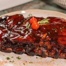 As costelas de porco defumadas ao estilo BBQ são servidas com arroz, batatas fritas crocantes e vinagrete refrescante -  (crédito: Ja Vai Li/Divulgação)