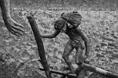 Fotografia da série "Gold - Mina de Ouro Serra Pelada". Retrata um homem trabalhador da mina em uma posição de esforço.  -  (crédito: Sebastião Salgado)
