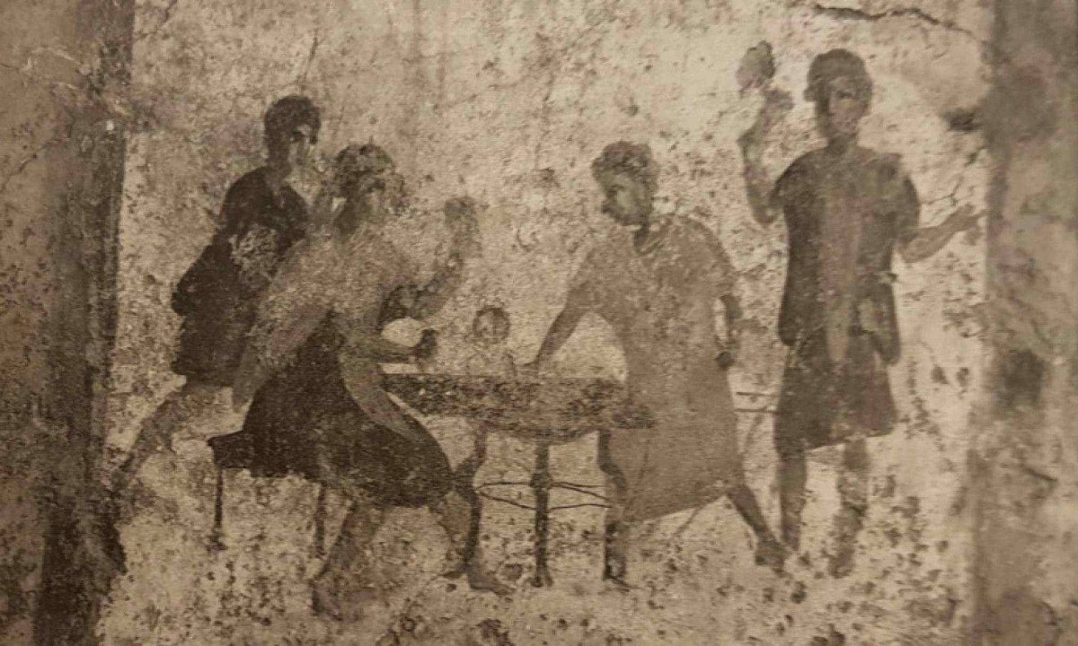 Uma das muitas pinturas de parede preservadas mostra uma cena corriqueira: pessoas reunidas em torno da comida e da bebida, num ambiente aparentemente popular e ível - (crédito: Reprodução) Uma das muitas pinturas de parede preservadas mostra uma cena corriqueira: pessoas reunidas em torno da comida e da bebida, num ambiente aparentemente popular e ível - (crédito: Reprodução)