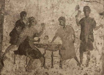 Uma das muitas pinturas de parede preservadas mostra uma cena corriqueira: pessoas reunidas em torno da comida e da bebida, num ambiente aparentemente popular e ível -  (crédito: Reprodução)