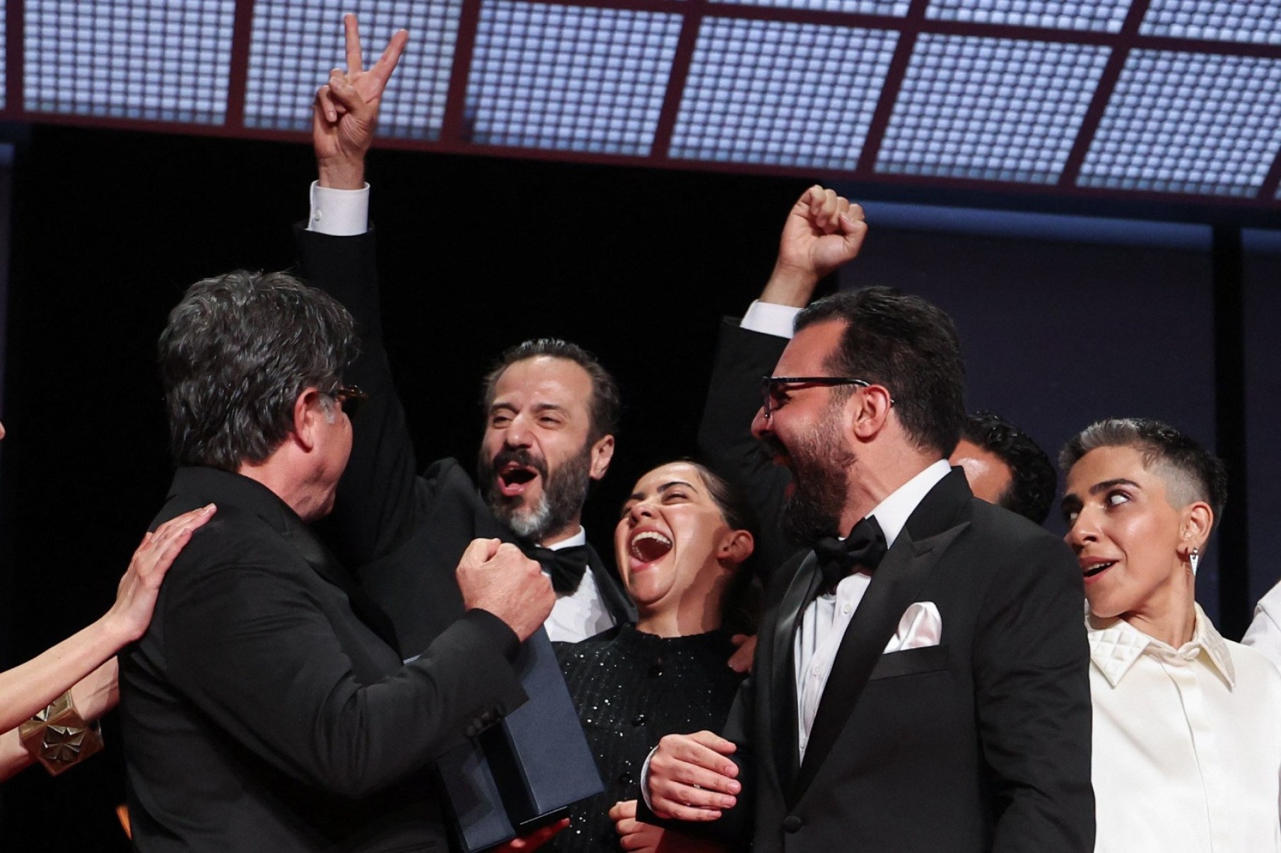O diretor, roteirista e produtor iraniano Jafar Panahi (E) e sua equipe comemoram no palco após ganhar a Palma de Ouro pelo filme Un 'Un simple accident'-Valery Hache/AFP