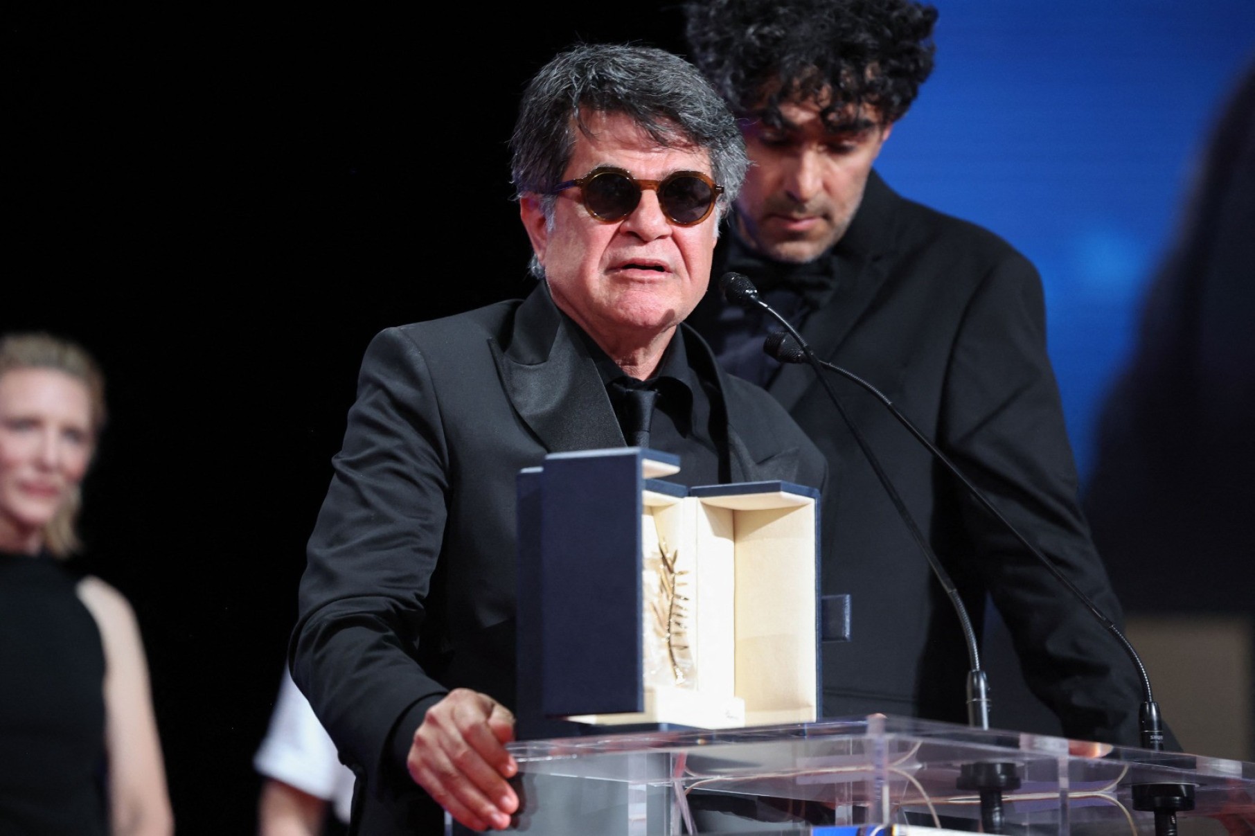 O diretor, roteirista e produtor iraniano Jafar Panahi comemora no palco após ganhar a Palma de Ouro pelo filme 'Un simple accident'-Valery Hache/AFP