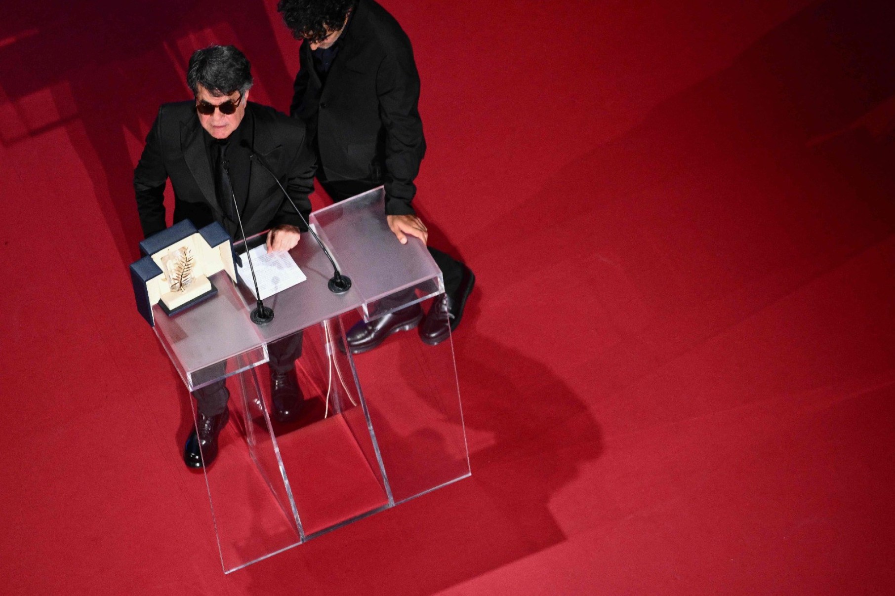 O diretor, roteirista e produtor iraniano Jafar Panahi comemora no palco após ganhar a Palma de Ouro pelo filme 'Un simple accident'-Antonin Thuillier/AFP