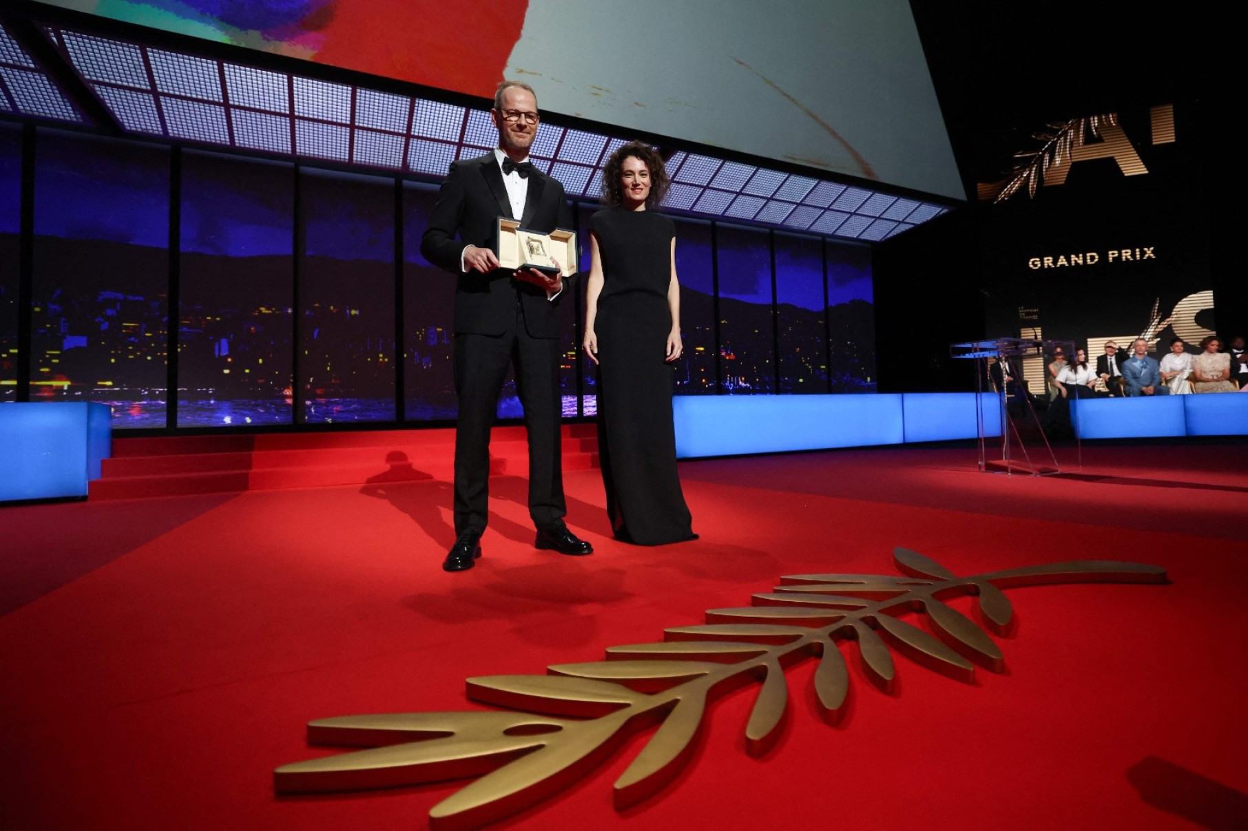 O diretor, roteirista e produtor iraniano Jafar Panahi comemora no palco após ganhar a Palma de Ouro pelo filme 'Un simple accident'-Valery Hache/AFP