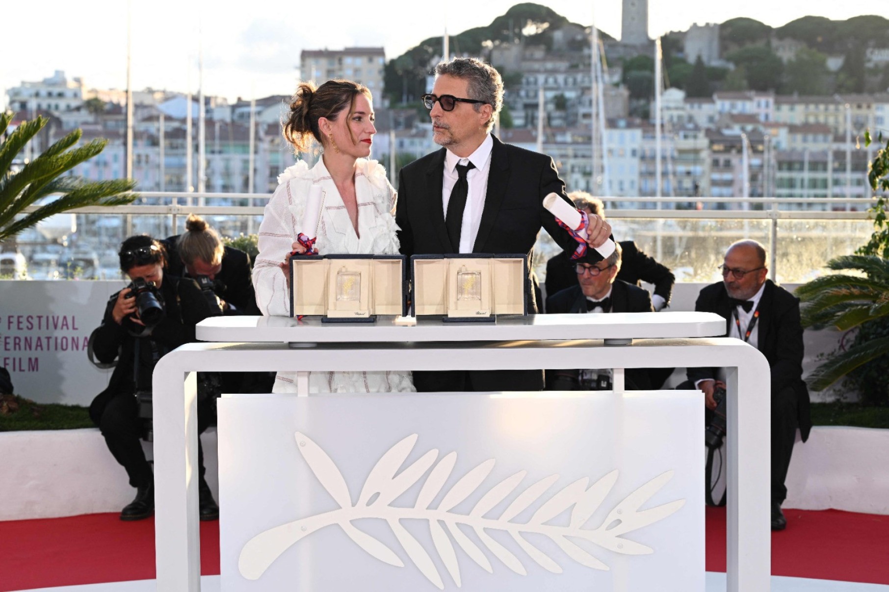 O diretor brasileiro Kleber Mendonça Filho posa com a produtora francesa Emilie Lesclaux durante sessão de fotos após ganhar o prêmio de Melhor Diretor pelo filme 'O agente secreto' e com o prêmio de Melhor Ator, entregue ao ator brasileiro Wagner Moura-Miguel Medina/AFP
