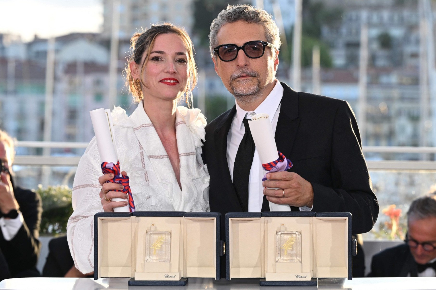 O diretor brasileiro Kleber Mendonça Filho posa com a produtora francesa Emilie Lesclaux durante sessão de fotos após ganhar o prêmio de Melhor Diretor pelo filme 'O agente secreto' e com o prêmio de Melhor Ator, entregue ao ator brasileiro Wagner Moura-Miguel Medina/AFP