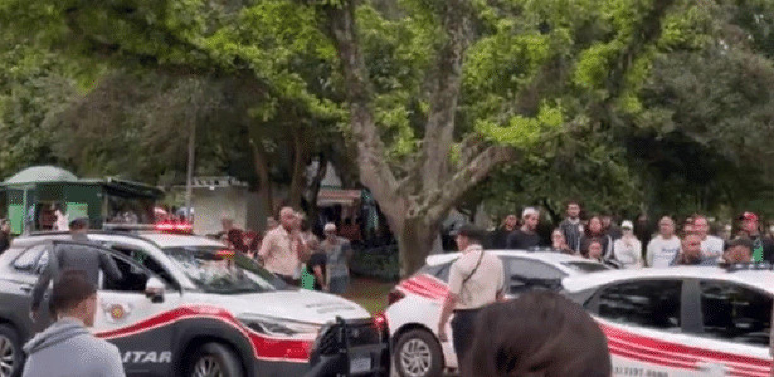Um registro publicado no X mostra diversas pessoas gritando 'racista' ao redor dos carros da polícia -  (crédito: X/Reprodução)