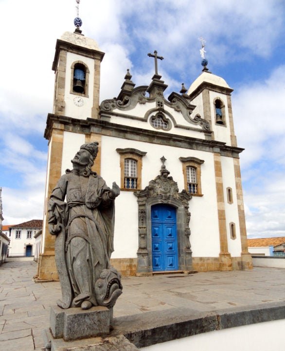 A basílica tem uma fachada em estilo rococó, com detalhes ornamentais sofisticados e um interior ricamente decorado com pinturas e entalhes dourados.