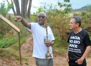 Ao lado do padre Geraldo Barbosa, Filomeno da Silva carrega crucifixo da capela encontrado na lama após a tragédia de Mariana -  (crédito: Jair Amaral/EM/D.A Press – 5/11/2017)