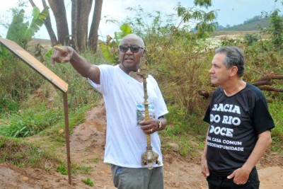 Ao lado do padre Geraldo Barbosa, Filomeno da Silva carrega crucifixo da capela encontrado na lama após a tragédia de Mariana -  (crédito: Jair Amaral/EM/D.A Press – 5/11/2017)