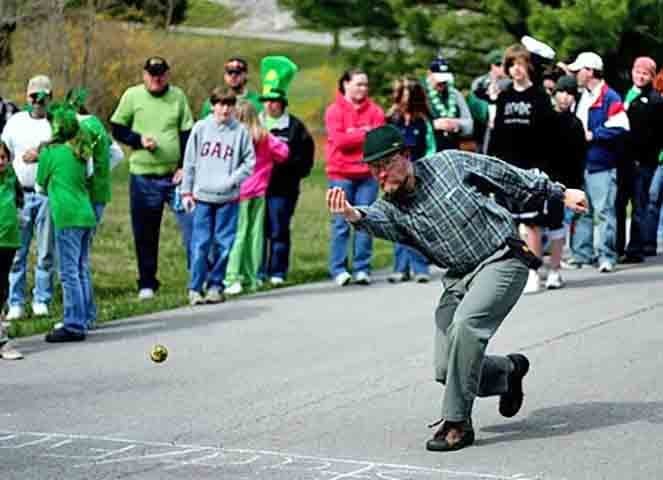 Boliche na Estrada - Parece um golfe. Os participantes jogam a bola em uma estrada rural e a pessoa que cruzar todo o comprimento da estrada primeiro vence a competição.-Reprodução do site balls.com/rules/irish-road-bowling
