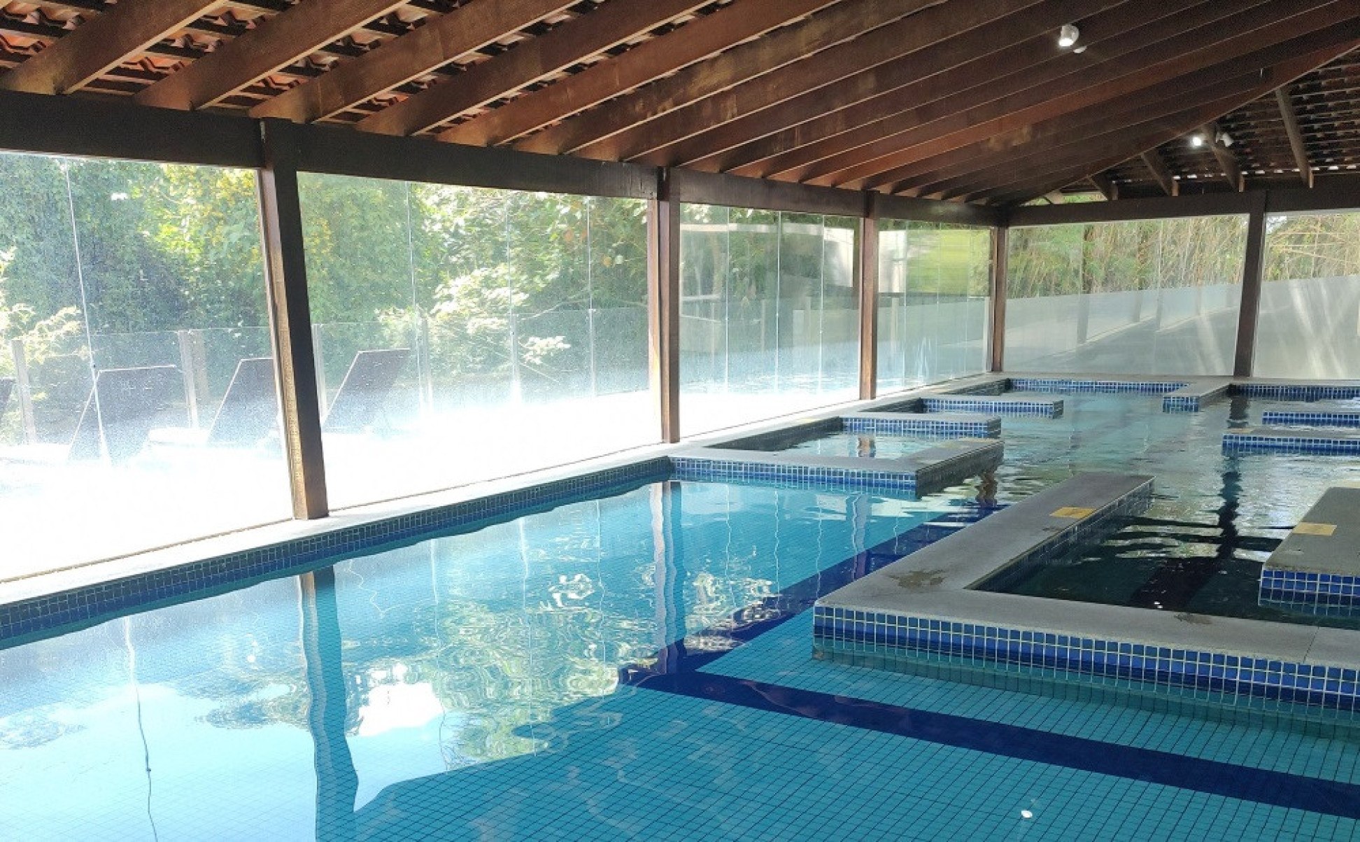 De frente para o horizonte da mata, as piscinas internas são um lugar de puro deleite