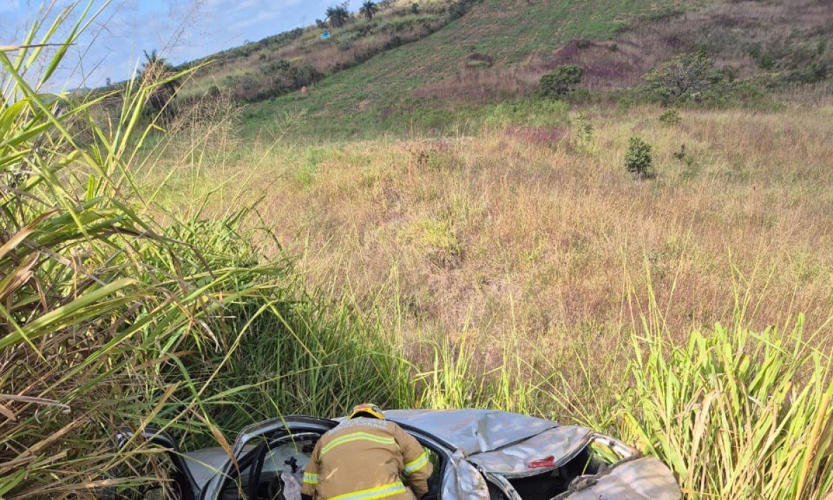 Equipe dos bombeiros faz o resgate da ageira que estava no interior do veículo com fratura no braço esquerdo  -  (crédito: CBMMG/Divulgação)