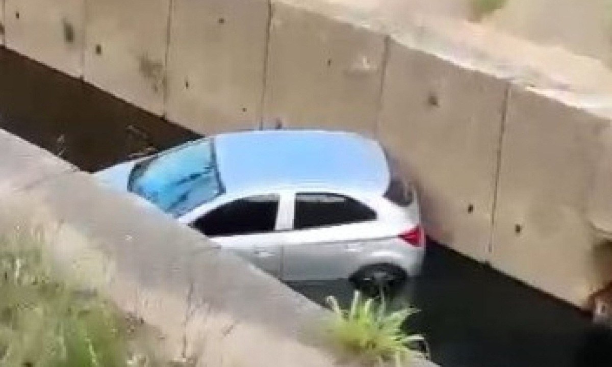 Até o início da manhã de hoje, o carro seguia dentro do córrego -  (crédito: Cristiano/Redes Sociais)