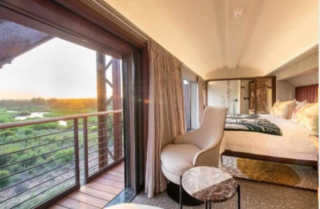 De dentro dos quartos, os hÃ³spedes tÃªm uma vista da savana africana, bioma caracterÃ­stico da regiÃ£o e composto por Ã¡rvores pequenas, arbustos e gramÃ­neas. 