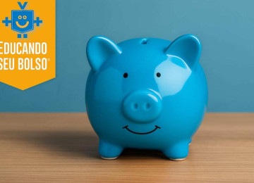 Cofrinho azul, com acabamento brilhante, sobre superfície de madeira clara; imagem usada para ilustrar artigo sobre cofrinho digital e caixinhas bancárias.  -  (crédito: Reprodução Educando seu Bolso)