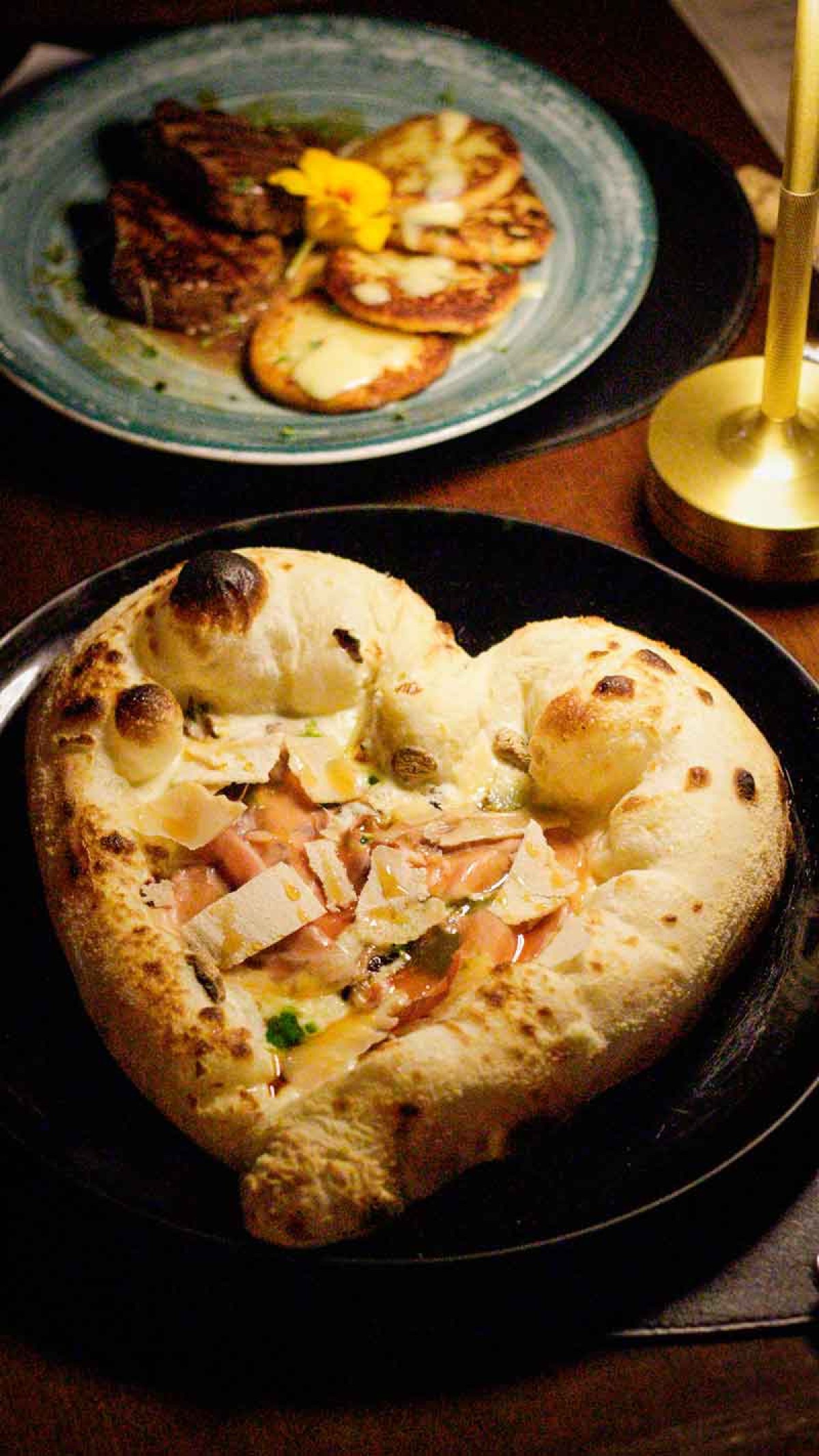 Pizza Amore al tartufo, do Barolio, leva creme à base de três queijos, muçarela de búfala, cogumelos salteados, presunto parma, pesto de rúcula, lascas de grana padano e mel trufado