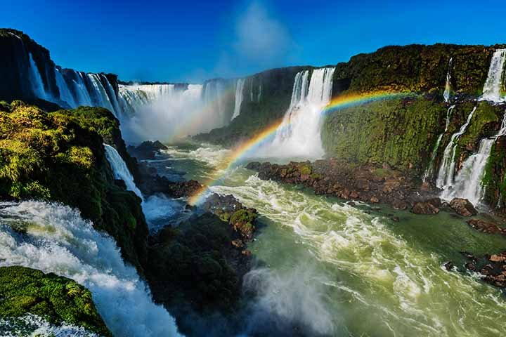 Cataratas de Iguaçu - Cidade: Foz do Iguaçu (Brasil) e Puerto Iguazú (Argentina) - O gugantesco volume de água que cai gera gotículas suspensas no ar. Com a luz solar incidindo nas partículas de água, arco-íris podem ser vistos com frequência.- Flickr Ben