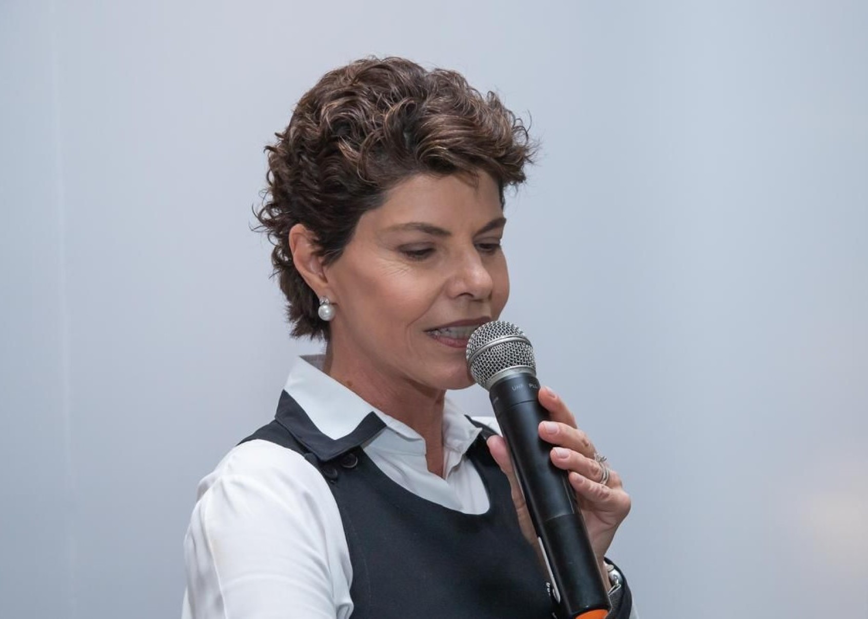 Bernadette Mendes, que coordena o voluntariado da AMR, diz que o Chá Solidário é evento tradicional, esperado e querido de BH Bernadette Mendes, voluntária da Associação Mineira de Reabilitação, fala ao microfone