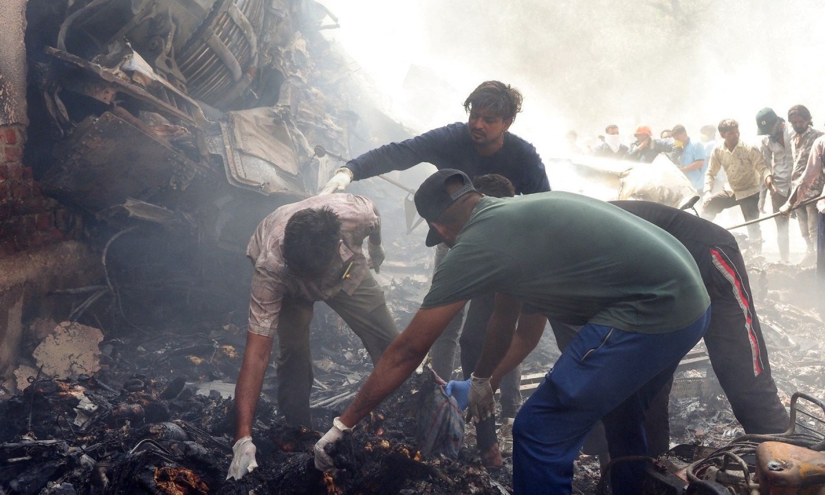Equipes de resgate trabalham no local onde o voo 171 da Air India caiu em uma área residencial perto do aeroporto de Ahmedabad em 12 de junho de 2025
       -  (crédito: Sam PANTHAKY / AFP)