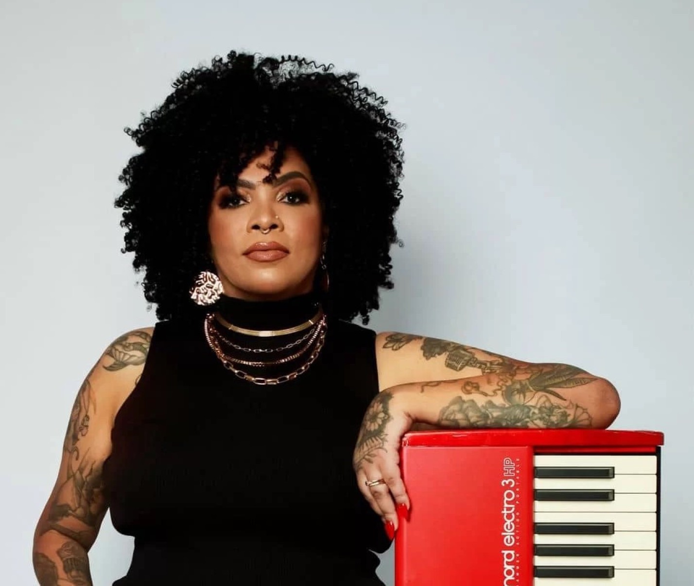 A instrumentista e cantora Glaw Nader está encostada em acordeom e olha para a câmera