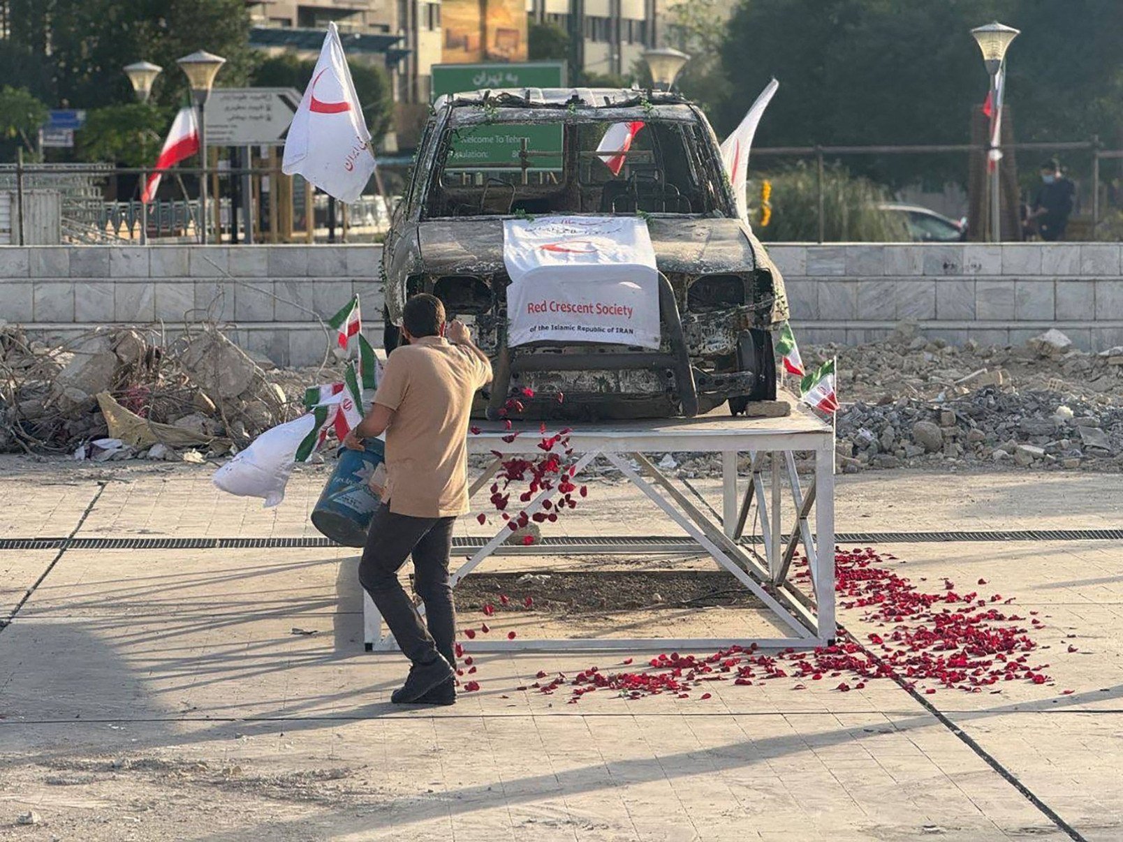 Médicos do Crescente Vermelho Iraniano colocam rosas em uma ambulância, alvo de um ataque israelense, como demonstrado em Teerã- Iranian Red Crescent / AFP
