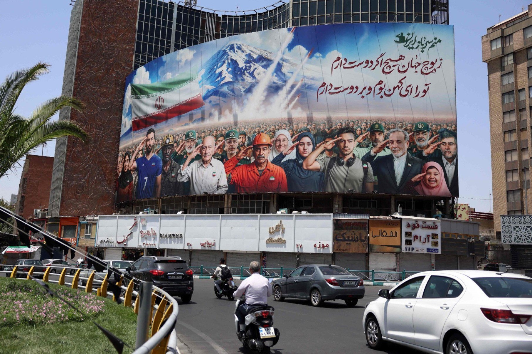 Faixa com uma pintura representando diversas categorias da sociedade iraniana é hasteada na fachada de um prédio em Teerã, com a mensagem 