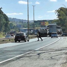 Pedestre se arrisca atravessando a pista da BR-040 entre os carros no Bairro Novo Boa Vista, em área de movimento intenso em Contagem -  (crédito:  Edésio Ferreira/EM/D.A Press)