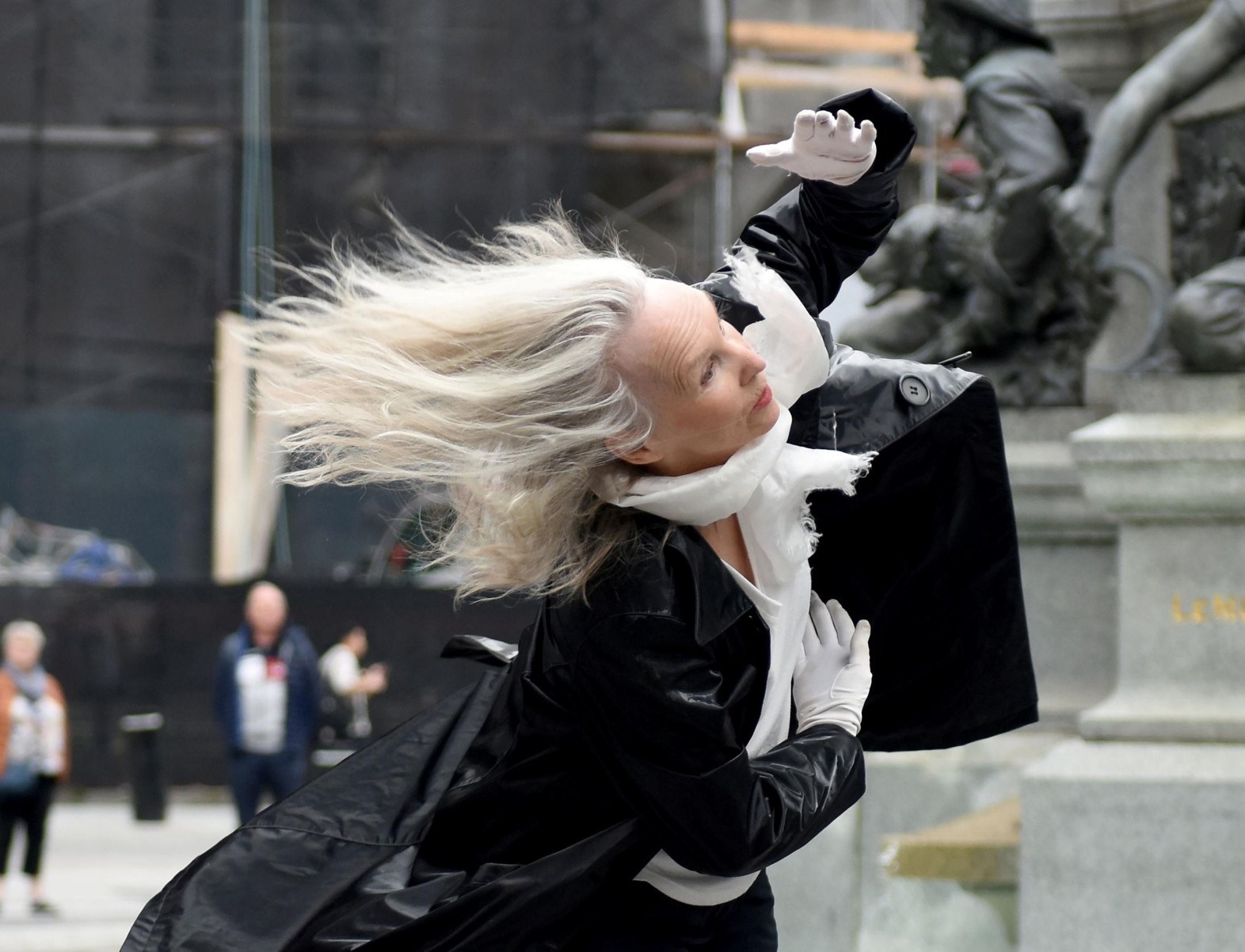 A artista canadense Louise Bredard, usando tailleur escuro, dança na rua