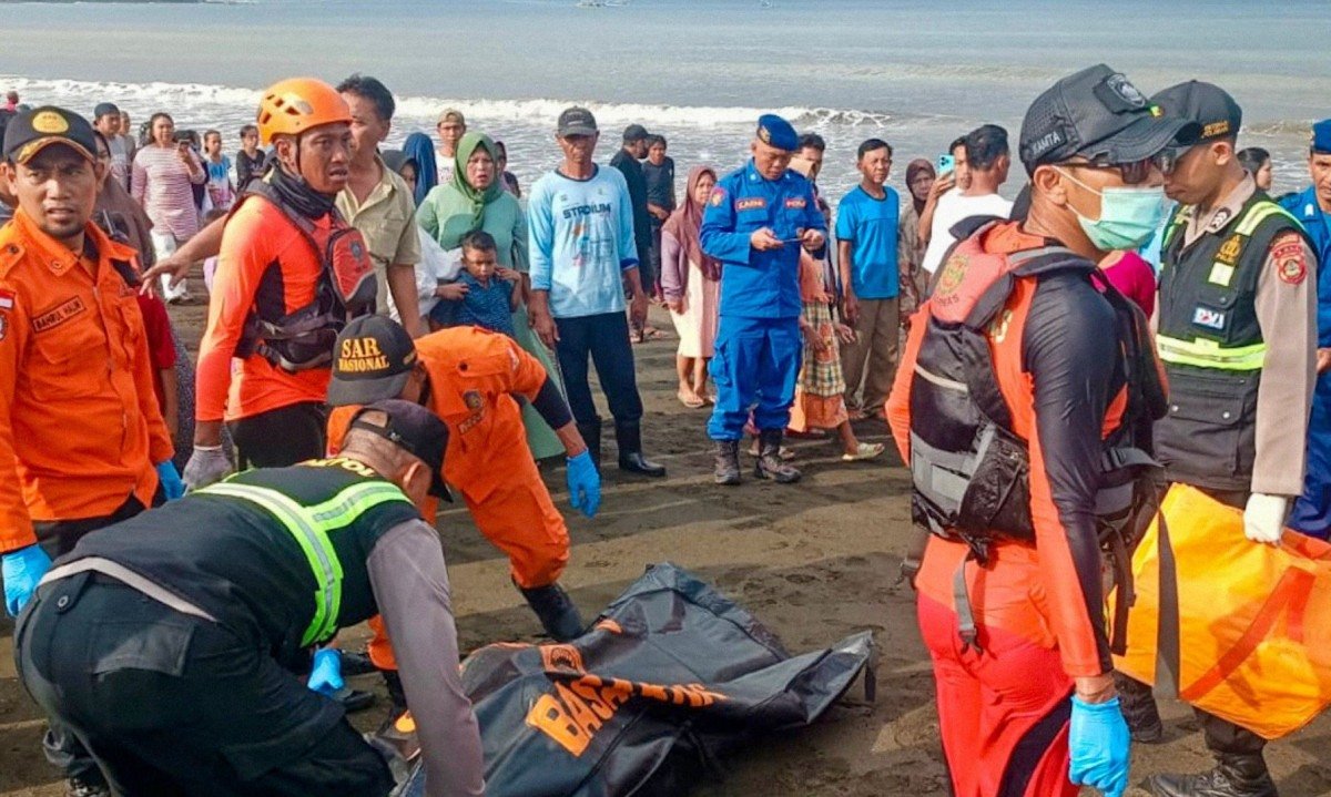 Equipe de resgate move corpo de vÃ­tima trazida para a costa por pescadores locais; balsa afundou a caminho da ilha turÃ­stica de Bali -  (crédito:  INDONESIAâ??S NATIONAL SEARCH AND RESCUE AGENCY (BASARNAS) / AFP)