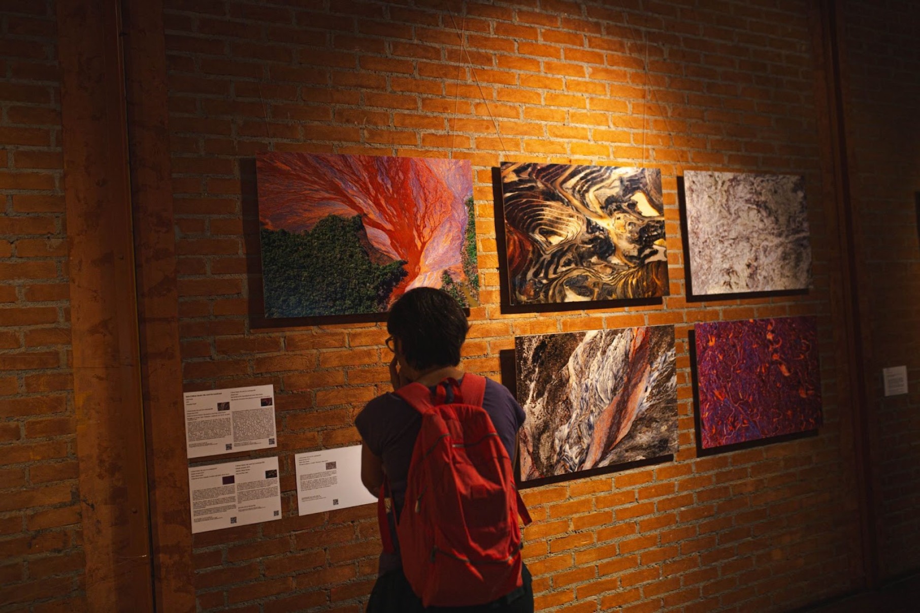Visitante vê fotos expostas na mostra Paisagens mineradas 