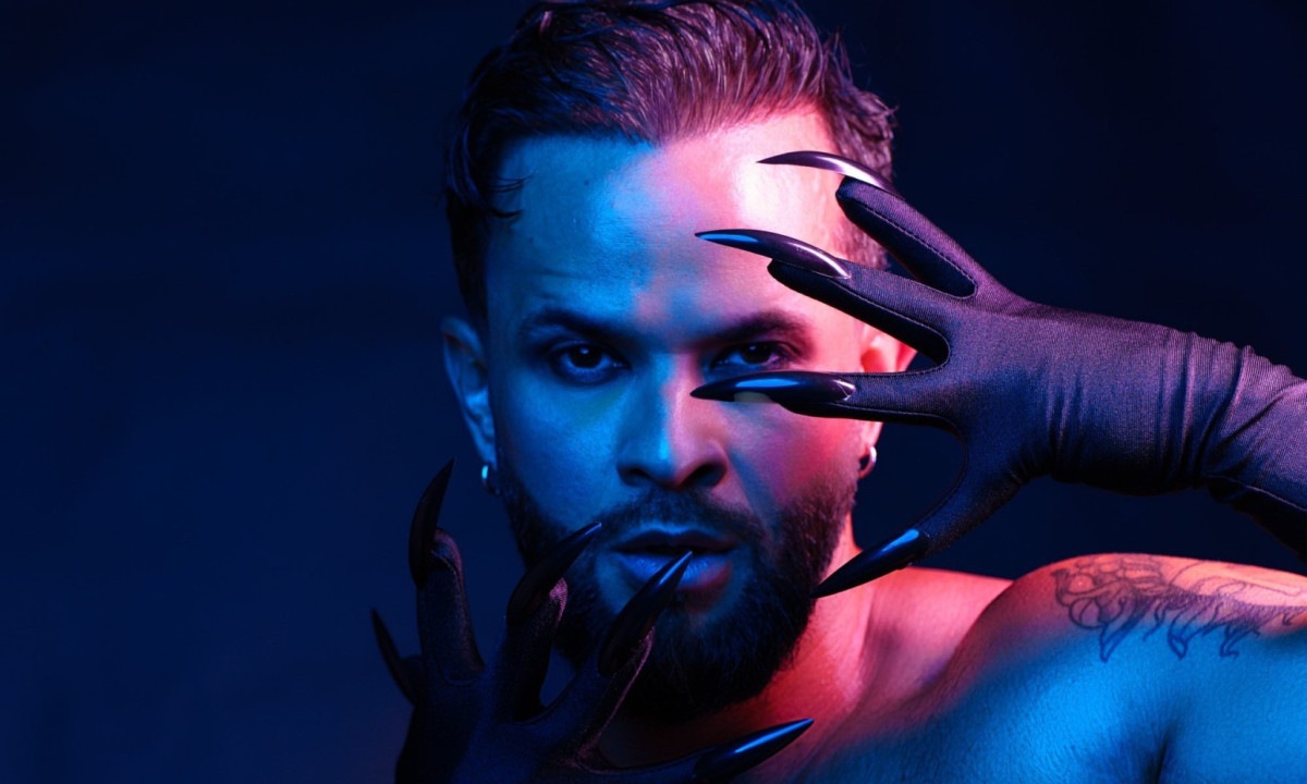 Sob luz azul, sem camisa e com unhas imensas à frente do rosto, Tiago Pimentel apresenta monólogo sobre desafios da população LGBTQIA 