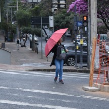 Pessoas que passavam na Rua do Ouro, esquina com Av. Do Contorno, por volta das 14h30, tiveram que abrir as sombrinhas para se protegerem do chuvisco -  (crédito: Gladyston Rodrigues/EM/D.A Press)