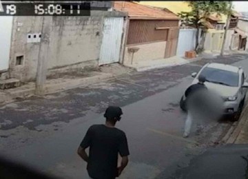 Dois dos três ladrões se aproximam de veículo que pretendem roubar -  (crédito: Reprodução Estado de Minas)