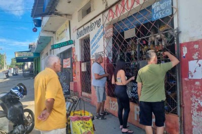 Compra com barreira: consumidores esperam na calçada e comerciante fica atrás de proteção metálica após o segundo assalto. Pesquisa mostra que medidas do tipo incomodam clientes -  (crédito: Luiz Ribeiro/EM/D.A Press)