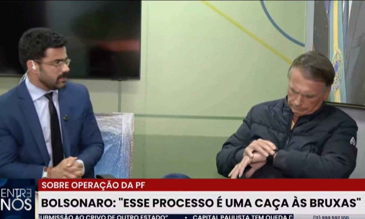 Ex-presidente Jair Bolsonaro confere as horas após repórter falar que tem que encerrar entrevista para ele cumprir medida cautelar -  (crédito: Reprodução/Redes Sociais)
