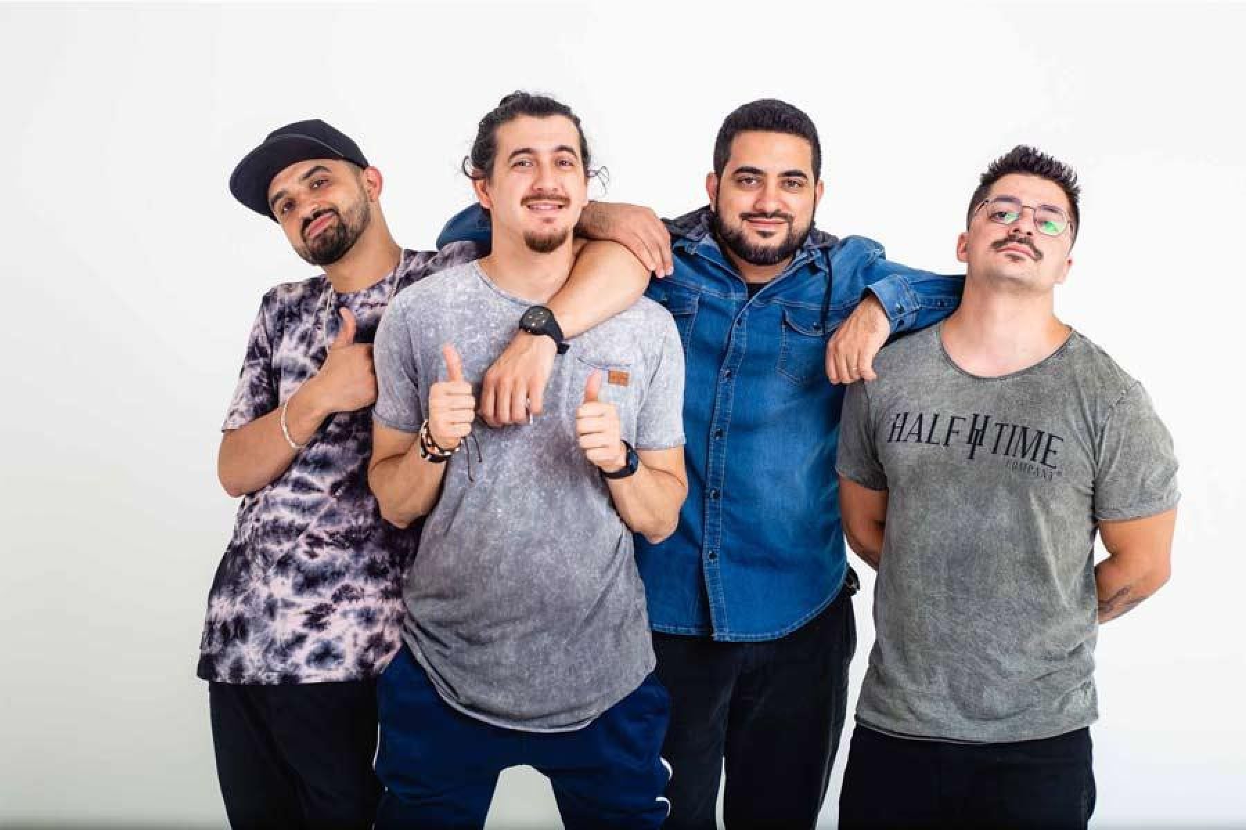 Quatro humoristas do grupo 4 Amigos estão abraçados e olham para a câmera