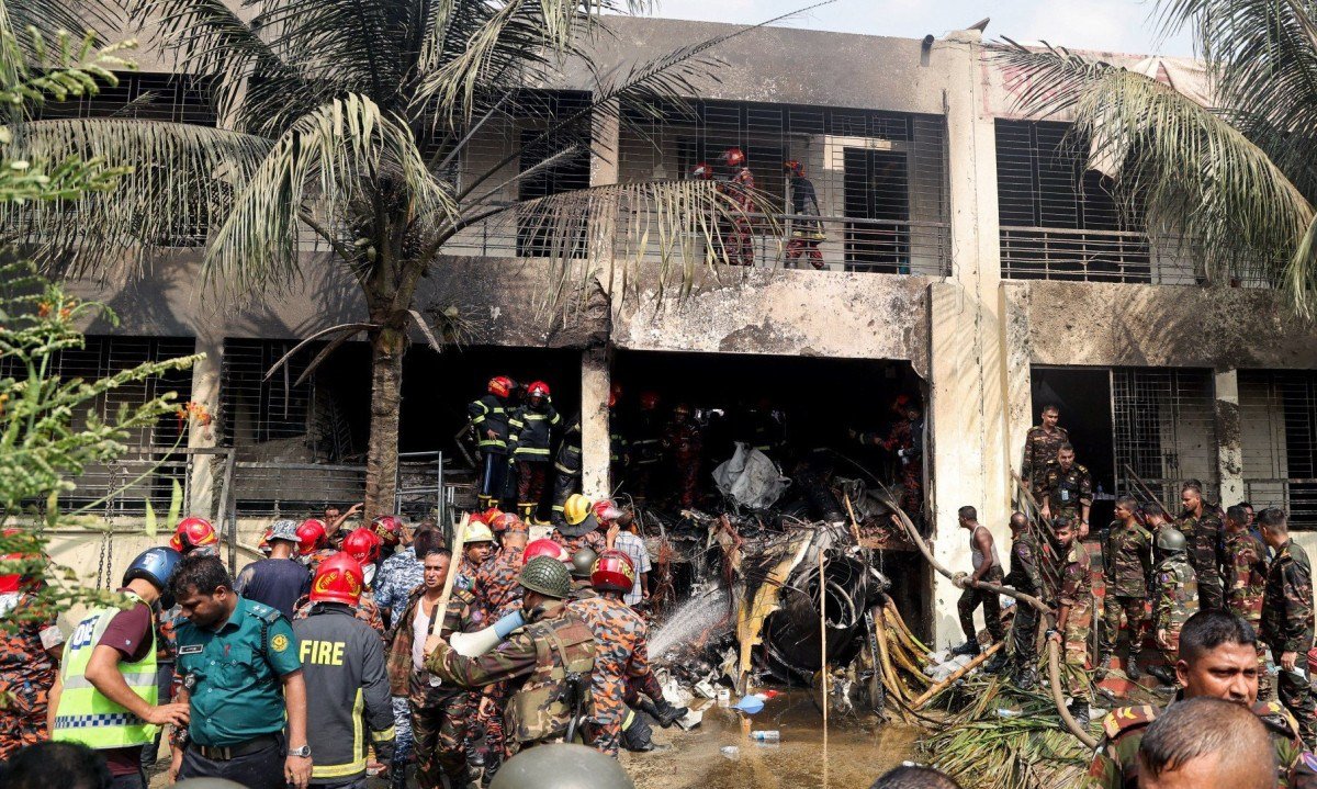 Corpo de bombeiros e equipe de segurança de Bangladesh realizam uma operação de busca e resgate após um jato de treinamento da Força Aérea ter caído em uma escola em Daca 
       -  (crédito: Abdul Goni / AFP)