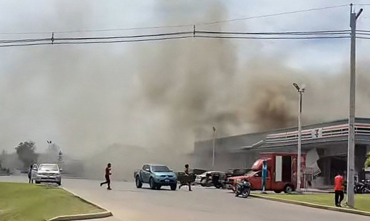 Fumaça saindo do telhado de uma loja de conveniência anexa a um posto de gasolina na Tailândia atingido por um ataque de foguete do Camboja -  (crédito: Cortesia do usuário do Facebook Chatchak Ratsamikaeo / AFP)