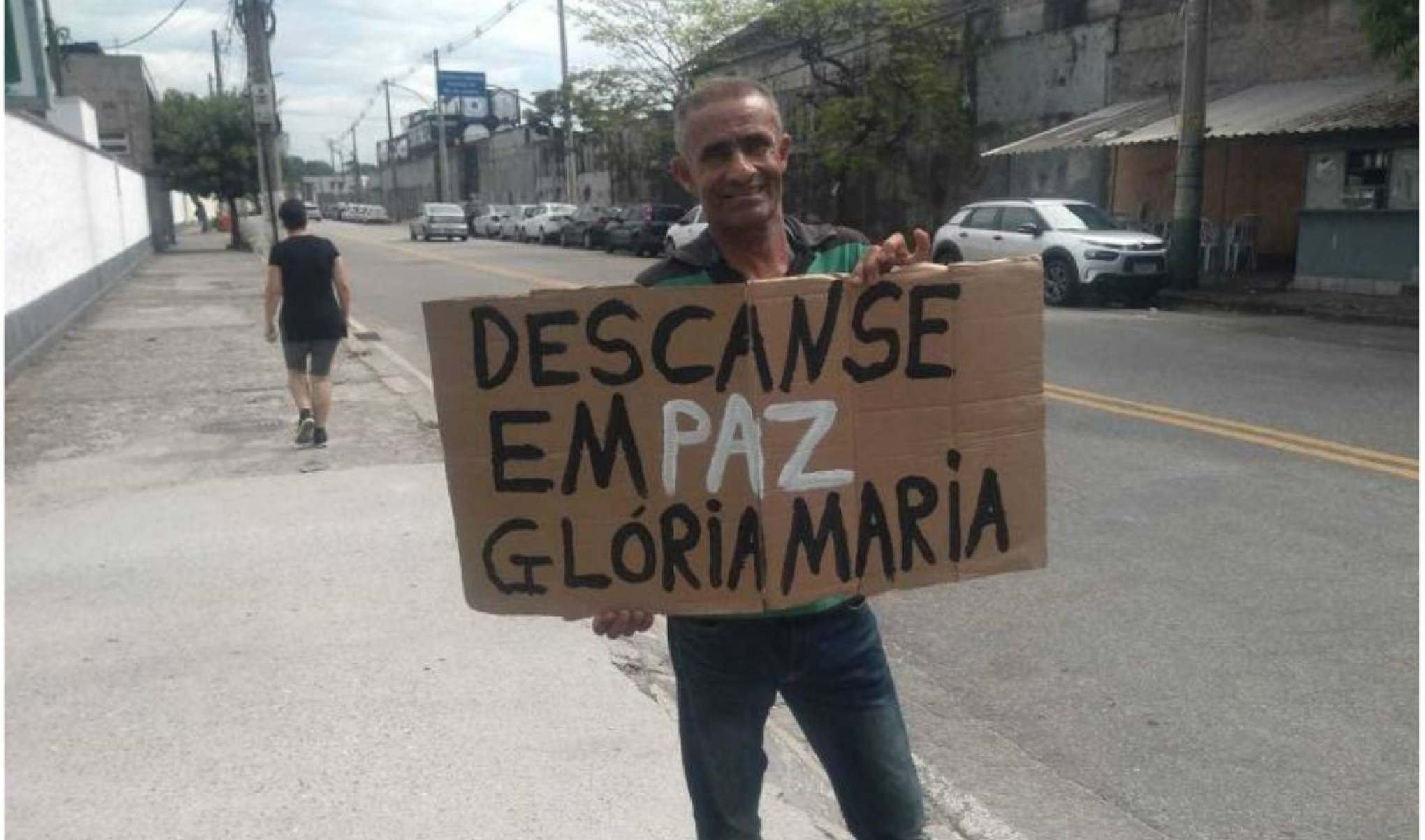 Carlos Henrique do Nascimento, 54, få da jornalista Glória Maria, levou cartaz em homenagem à repórter em frente ao Cemitério da Penitencia, no Caju -Matheus Rocha - 3.fev.23/Folhapress 