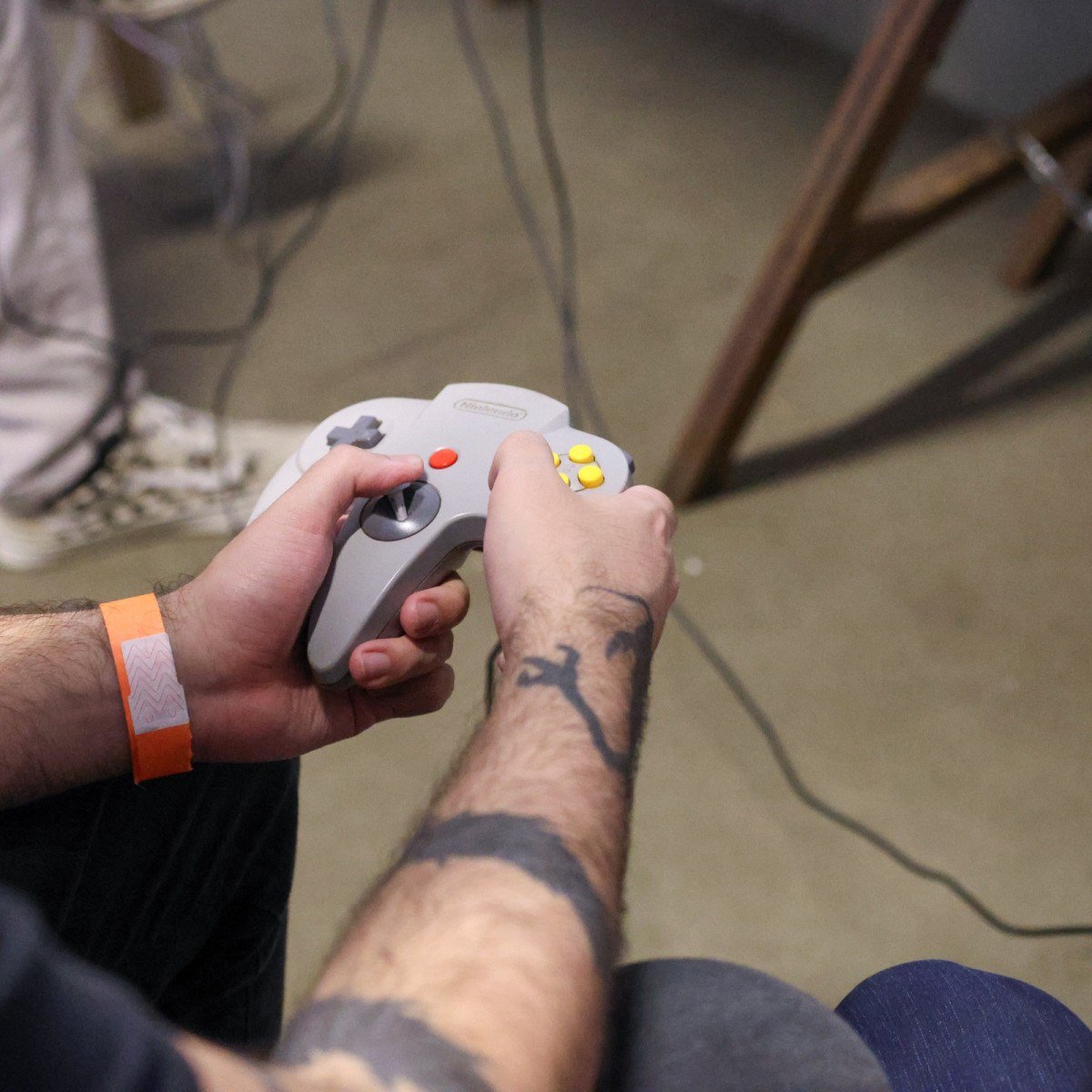 Controle do Nintendo 64 reforça a nostalgia gamer no torneio retrô de tiro.