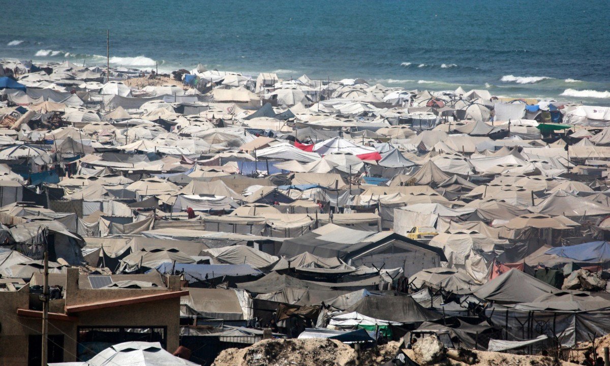  Tendas usadas como abrigos temporários por palestinos deslocados são montadas ao redor de estruturas danificadas pela guerra ao longo da praia da Cidade de Gaza, em 8 de agosto de 2025 -  (crédito:  Bashar Taleb/AFP)