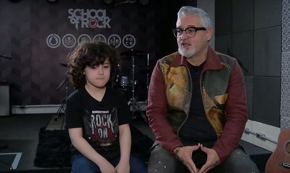 O jovem baixista João Chapman e o pai, Ricardo Koctus, baixista do Pato Fu, sentados no palco