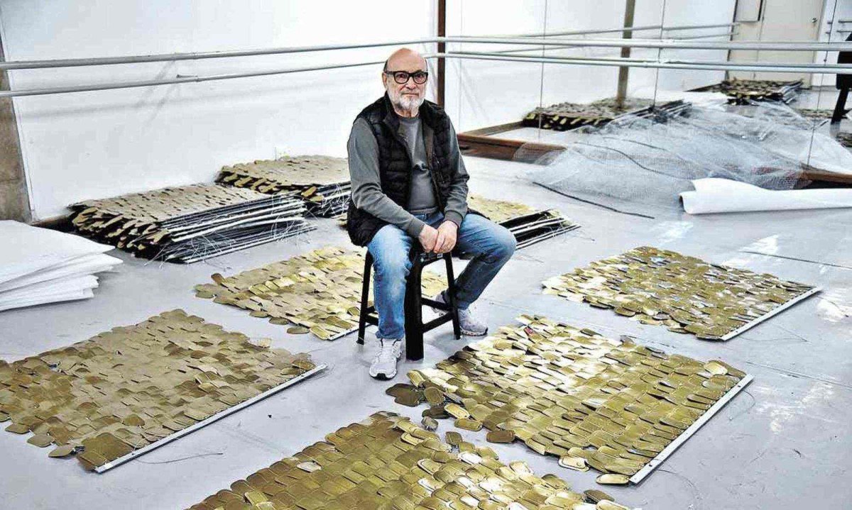 Paulo Pederneiras com parte das placas com tampas de latas de sardinha que formam o cenário de "Piracema" -  (crédito: Gladyston Rodrigues/EM D.A Press)